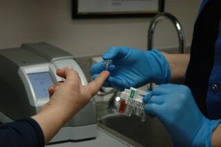 Nurse Assistant Poking Finger While Wearing Disposable Gloves