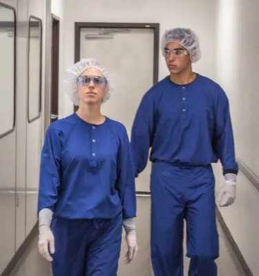 2 People Walking in a Cleanroom With Hair Net and Booties