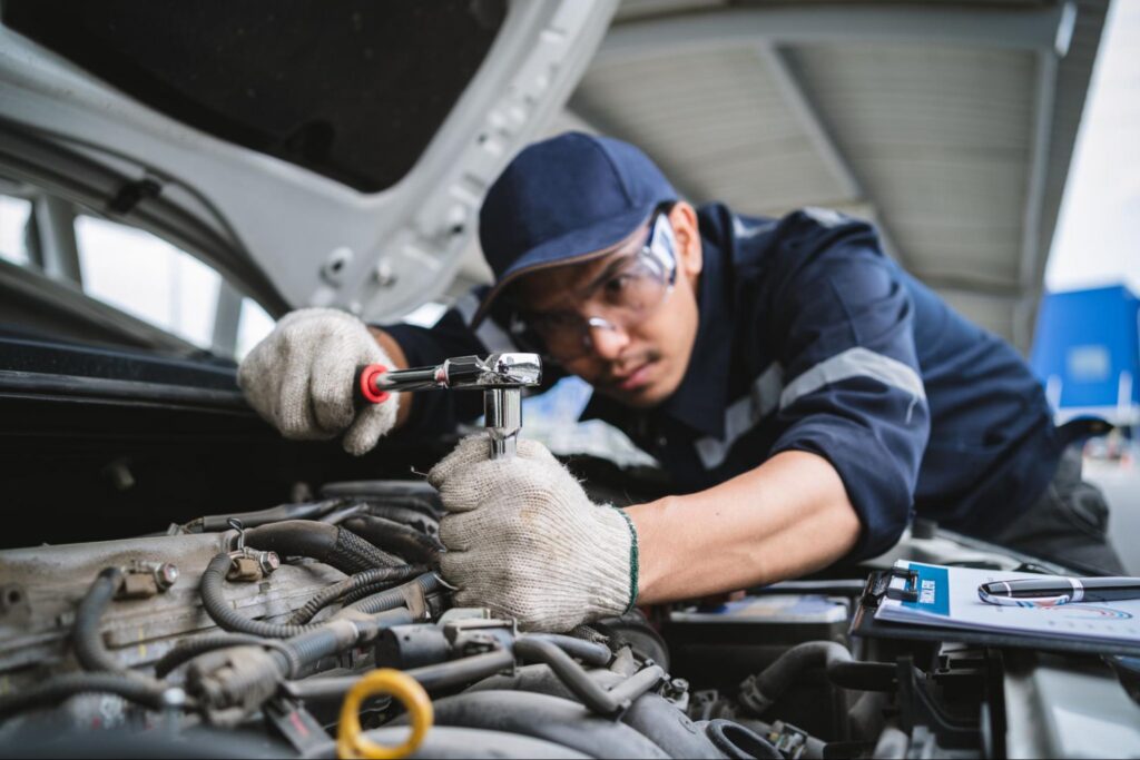 Automotive Man Working on a Car in an Industrial Uniform