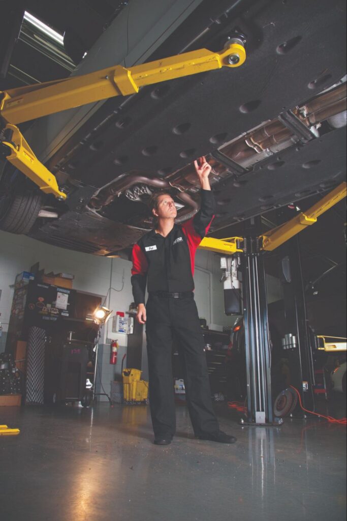 Automotive Mechanic Working on a Car in Uniform