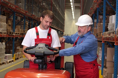 Workers With Forklift In Warehouse