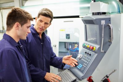 engineer and apprentice using automated milling machine engineer and apprentice using automated milling machine