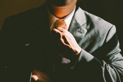 well dressed business man adjusting his neck tie