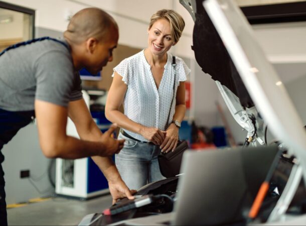 Car Mechanic Wearing a Uniform Helping a Customer
