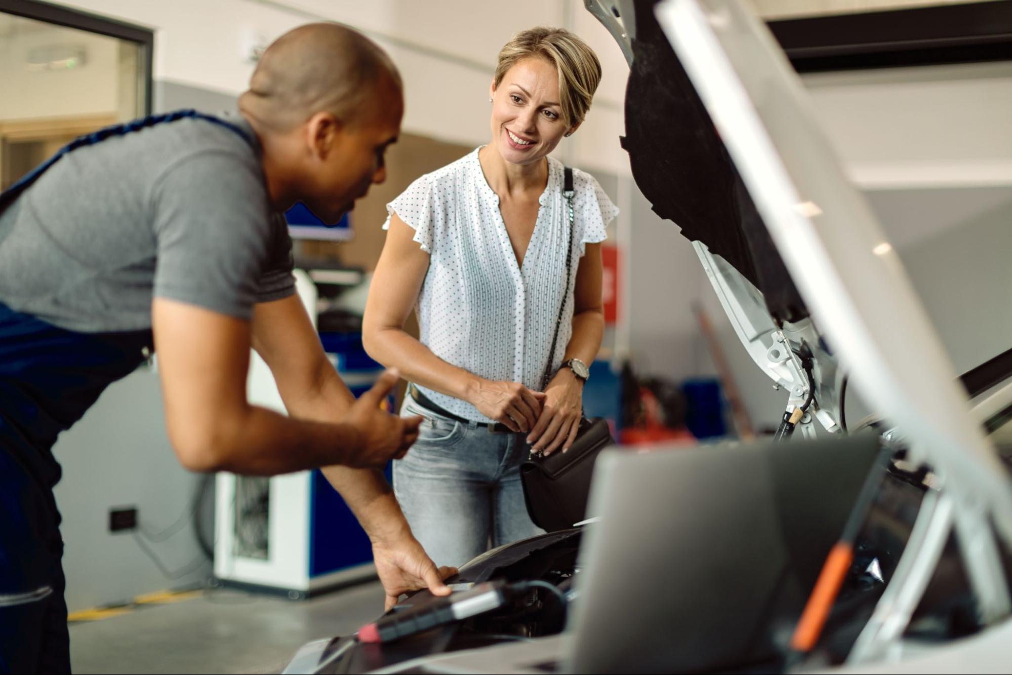 Car Mechanic Wearing a Uniform Helping a Customer