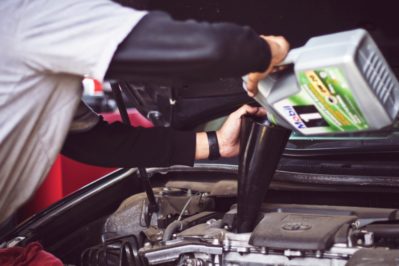 mechanic changing car engine oil