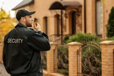 male security guard with portable radio transmitter outdoors