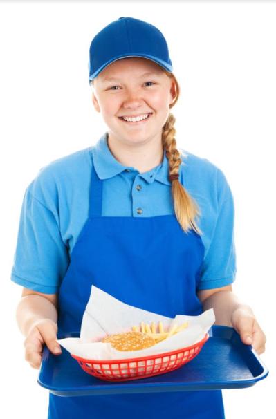 fast food worker serving a hamburger and french fries