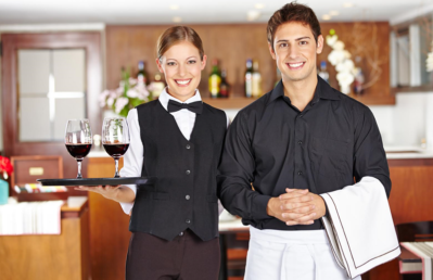 Team of waiter staff with wine glasses in a restaurant