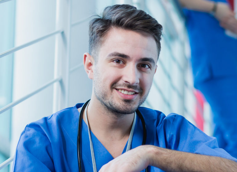 Smiling young doctor wear medical uniform with stethoscope looking at camera