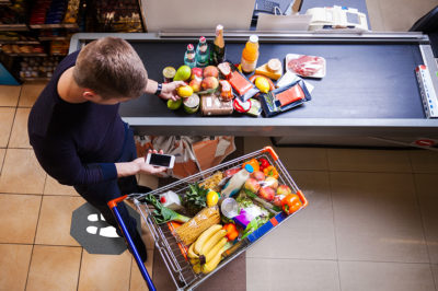 Young man before checkout in supermarket