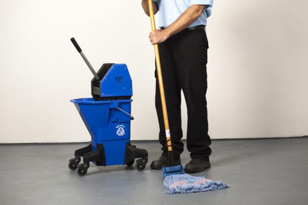 Male janitor in uniform mopping floor