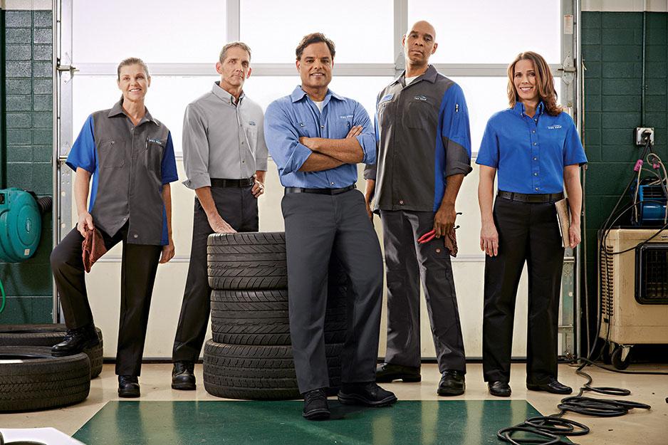 Team of auto mechanic workers in uniforms