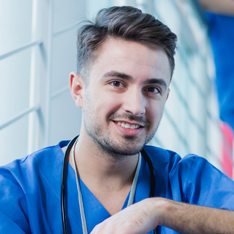 Smiling young doctor wear medical uniform with stethoscope looking at camera