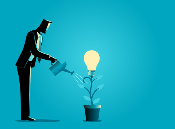 Business concept illustration of a businessman watering young plant with light bulb on it.