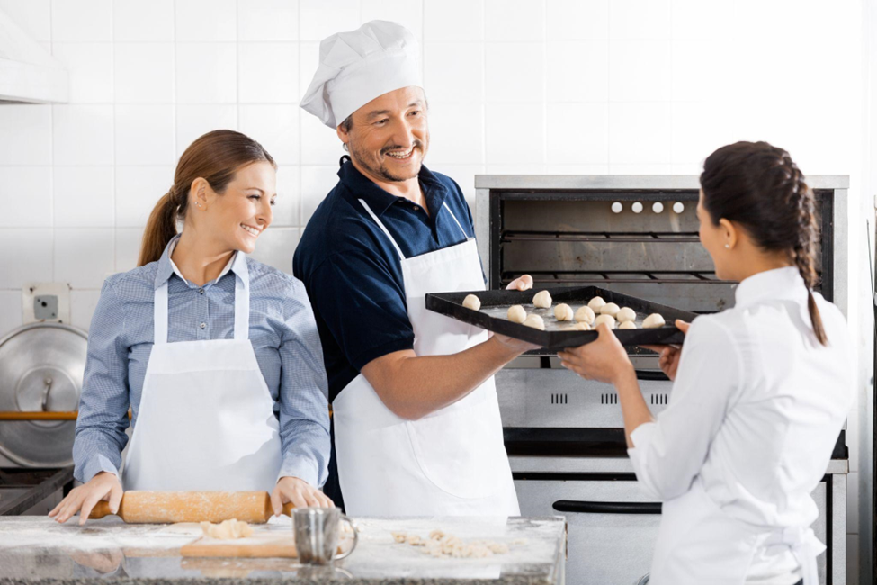 Happy chefs baking at commercial kitchen