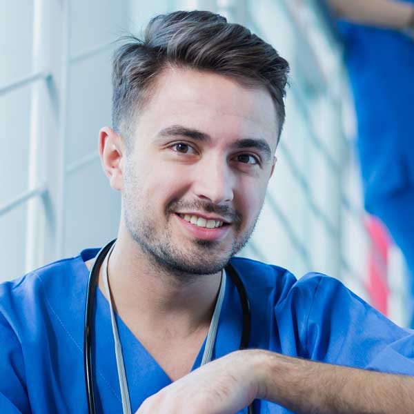 Smiling young doctor wear medical uniform with stethoscope looking at camera