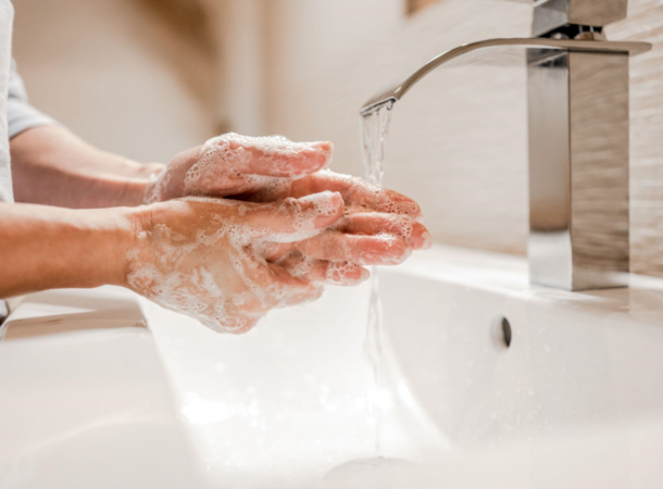 Gym employee washing their hands in the bathroom