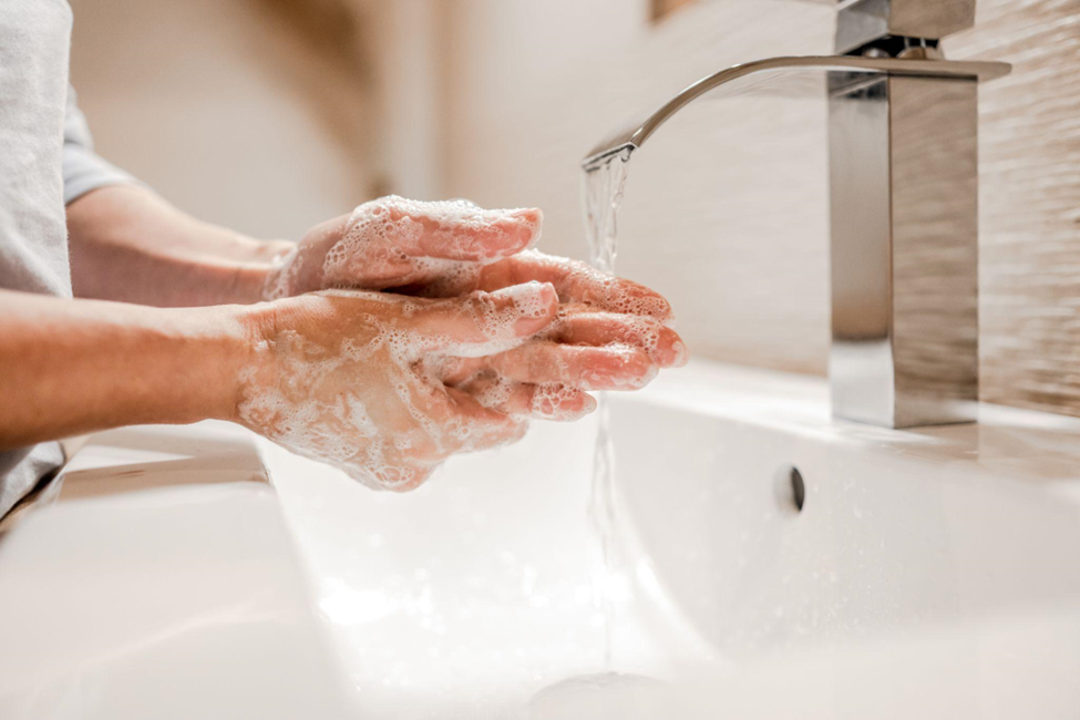 Gym employee washing their hands in the bathroom