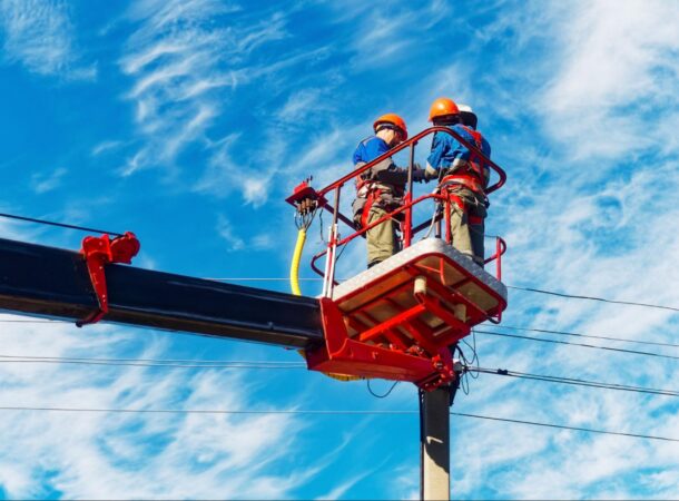 Industrial Workers Wearing FR Uniforms While Working on an Electric Pole