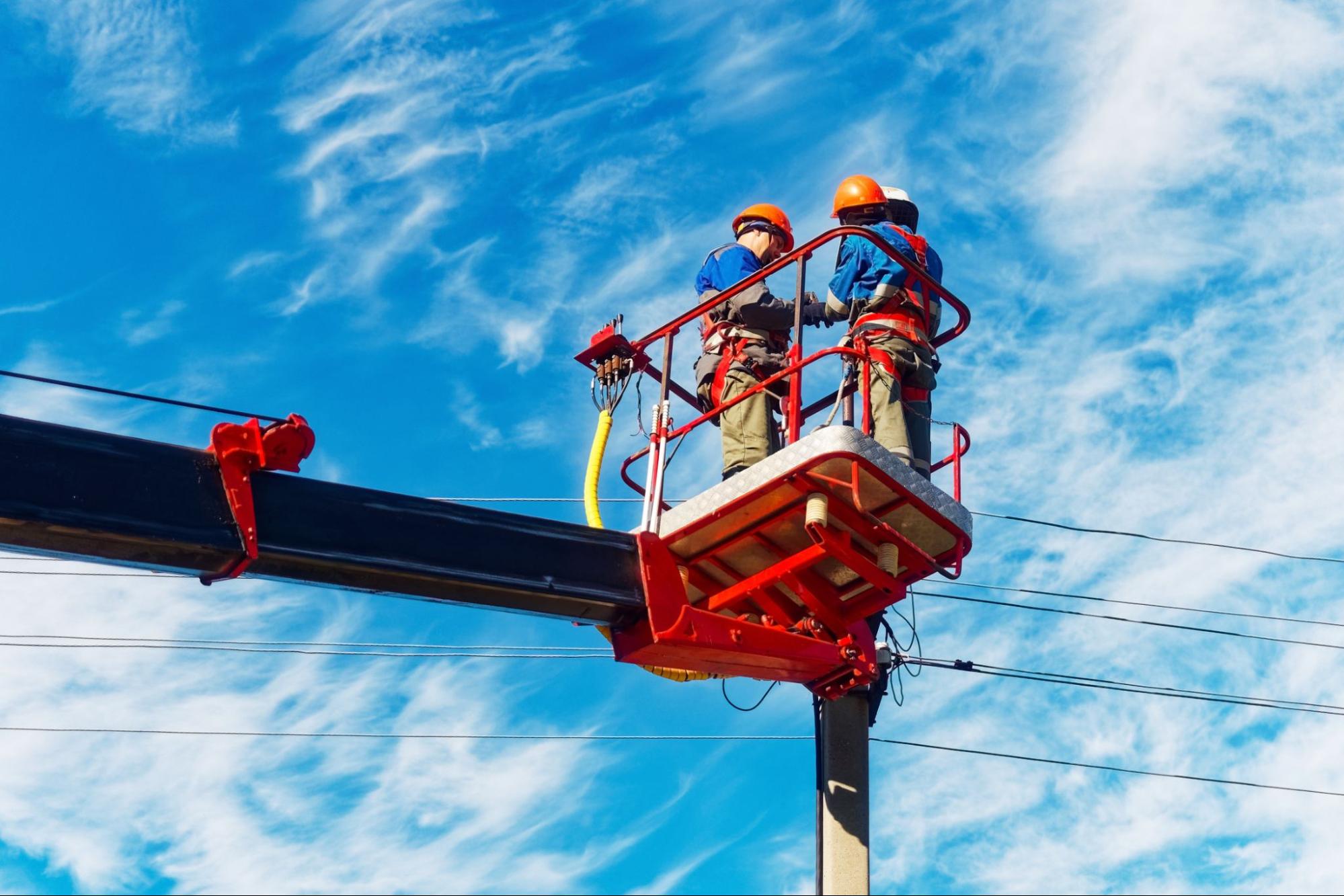 Industrial Workers Wearing FR Uniforms While Working on an Electric Pole