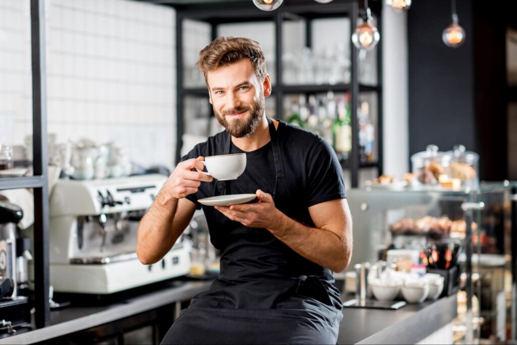 Barista Wearing a Hospitality Apron and Enjoying Some Coffee
