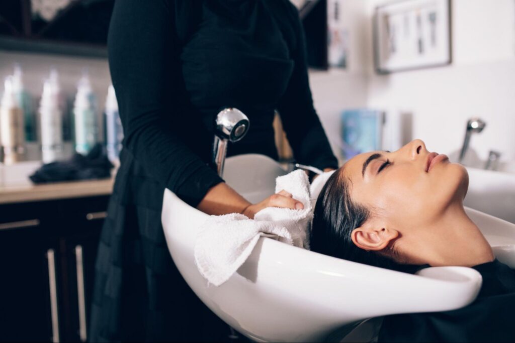 Woman at a Salon Washing Hair with a Prudential Overall Supply Towel